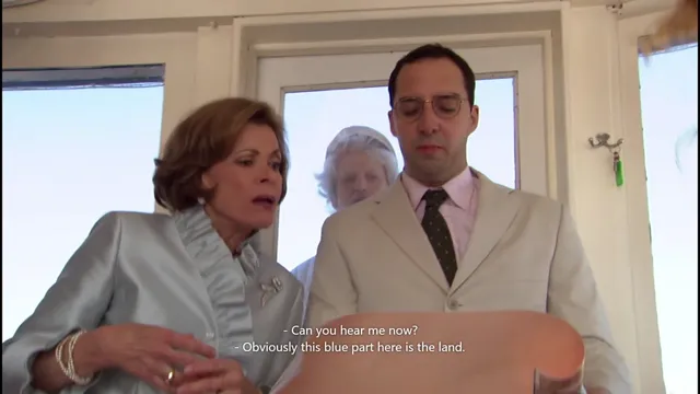 A well-dressed older woman and a man in a suit examine something off-screen while a third person lurks in the background, in a scene from the TV show Arrested Development. The subtitle references a humorous misunderstanding about a map or model.